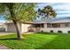 Well-kept home with a front yard, mature tree, brick fence, and an outdoor fireplace at 12703 W Shadow Hills Dr, Sun City West, AZ 85375