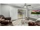 Bright living room with sliding glass doors, ceiling fan, and comfortable seating area with side tables at 12703 W Shadow Hills Dr, Sun City West, AZ 85375