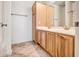 Bathroom featuring double sinks with wood cabinets, decorative mirrors, and tile flooring at 15331 W Roma Ave, Goodyear, AZ 85395