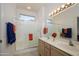 Bright bathroom featuring double sinks, large mirror, and glass shower doors at 15642 W Arbor Trl, Surprise, AZ 85374