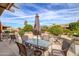 Outdoor patio with shade umbrella, beautiful landscaping, seating and table for relaxing and entertaining at 15642 W Arbor Trl, Surprise, AZ 85374