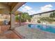 Backyard featuring a pool, outdoor kitchen, covered patio with pergola and lush greenery at 16018 W Shangri La Rd, Surprise, AZ 85379