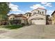 Beautiful two-story home with a spacious driveway, lush green lawn, and mature landscaping for a welcoming curb appeal at 16018 W Shangri La Rd, Surprise, AZ 85379