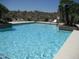 Sparkling community pool with lounge chairs, desert landscaping and mountain views at 16657 E Gunsight Dr # 182, Fountain Hills, AZ 85268
