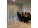 Dining area with a solid wood table, comfortable upholstered chairs, and neutral window treatments at 17622 W Missouri Ave, Litchfield Park, AZ 85340