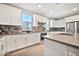 Modern kitchen with white cabinets, stainless steel appliances, and grey backsplash at 17819 E Oak Creek Canyon Ln, Rio Verde, AZ 85263