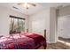 Bright bedroom with a plaid bedspread, ceiling fan, and a large window with exterior views at 18813 N Summerbreeze Way, Surprise, AZ 85374
