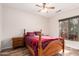 Bedroom with wood-look floors, bright window, and traditional furnishings at 18813 N Summerbreeze Way, Surprise, AZ 85374