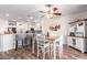 Inviting dining area adjacent to an open kitchen, featuring modern décor, a ceiling fan, and natural light, great for Gathering meals at 18813 N Summerbreeze Way, Surprise, AZ 85374