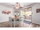 Cozy dining area featuring a wooden table with white chairs, a stylish ceiling fan, and sliding glass doors leading to the backyard at 18813 N Summerbreeze Way, Surprise, AZ 85374
