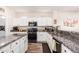 Bright kitchen features granite countertops, stainless steel appliances, and white cabinets at 18813 N Summerbreeze Way, Surprise, AZ 85374