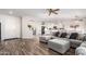Bright and airy living space featuring a large sectional sofa, wood-look floors, and an open layout connecting to the kitchen at 18813 N Summerbreeze Way, Surprise, AZ 85374