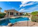 Inviting backyard featuring a private pool with a rock feature, desert landscaping, and covered patio perfect for outdoor living at 18813 N Summerbreeze Way, Surprise, AZ 85374