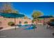 Backyard pool with a small waterfall feature, two umbrellas, and desert landscaping at 18813 N Summerbreeze Way, Surprise, AZ 85374