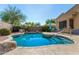 Backyard pool featuring lush landscaping, rock waterfall, and a sunning ledge at 18813 N Summerbreeze Way, Surprise, AZ 85374