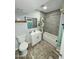 Renovated bathroom with gray tile surround, modern fixtures, and wood-look floors at 1953 W Granada Rd, Phoenix, AZ 85009