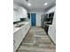 Bright kitchen with stainless steel appliances, white cabinets, dark backsplash, and wood-look flooring at 1953 W Granada Rd, Phoenix, AZ 85009