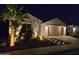 Well-lit home exterior at night with palm tree and desert landscaping at 20012 W Campbell Ave, Buckeye, AZ 85396
