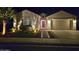 Charming home exterior at night with lighted walkway and manicured landscaping at 20012 W Campbell Ave, Buckeye, AZ 85396