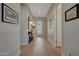Bright hallway with wood-look tile, elegant light fixtures and decorative artwork adorning the walls at 20012 W Campbell Ave, Buckeye, AZ 85396