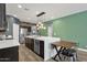 Beautiful open kitchen featuring stainless steel appliances, an island with seating, and stylish pendant lighting at 20308 E Broadmoor Trl, Queen Creek, AZ 85142