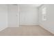 An empty bedroom with neutral carpet and trim, and a white door at 25449 W Graham Trl, Buckeye, AZ 85326