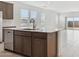 Island with quartz countertop and cabinets in the kitchen and view of the living room at 25449 W Graham Trl, Buckeye, AZ 85326