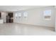 Open-concept living room with tile flooring flowing into the kitchen area at 25449 W Graham Trl, Buckeye, AZ 85326