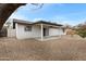 Spacious backyard featuring a covered patio, rock landscaping, and mature trees at 2593 E Commonwealth Cir, Chandler, AZ 85225