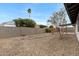 View of private backyard with rock landscaping, mature trees, and block fencing at 2593 E Commonwealth Cir, Chandler, AZ 85225