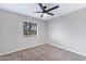 This bedroom features neutral carpet, paint, ceiling fan, and natural light from the window at 2593 E Commonwealth Cir, Chandler, AZ 85225