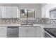Close-up shot of bright kitchen featuring a stainless steel sink and gray backsplash at 2593 E Commonwealth Cir, Chandler, AZ 85225