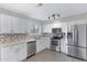 Bright kitchen features stainless steel appliances, gray backsplash, and white cabinets at 2593 E Commonwealth Cir, Chandler, AZ 85225