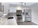 Bright kitchen features stainless steel appliances, gray backsplash, and white cabinets at 2593 E Commonwealth Cir, Chandler, AZ 85225