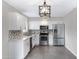 Bright kitchen featuring stainless steel appliances, white cabinets, and mosaic tile backsplash at 2593 E Commonwealth Cir, Chandler, AZ 85225