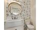 Charming powder room featuring wallpaper, modern fixtures, and a stylish mirror at 28422 N 32Nd Ln, Phoenix, AZ 85083