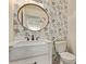 Powder room showcasing designer wallpaper, a modern faucet, and an oval mirror at 28422 N 32Nd Ln, Phoenix, AZ 85083