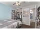 This bedroom features a large bed, closet, ceiling fan, and doorway leading to a bathroom at 28422 N 32Nd Ln, Phoenix, AZ 85083