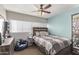 Cozy bedroom featuring a comfy bed with a padded headboard, blue accent wall, and a ceiling fan at 28422 N 32Nd Ln, Phoenix, AZ 85083