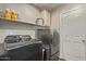 This laundry room boasts modern front-loading washer and dryer units with upper cabinet storage at 28422 N 32Nd Ln, Phoenix, AZ 85083