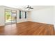 Bright bedroom features wood floors, a ceiling fan, and a sliding glass door to the backyard at 3410 E Pageant Pl, Gilbert, AZ 85297