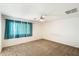 Bright bedroom with neutral carpeting and one window with teal curtains at 3410 E Pageant Pl, Gilbert, AZ 85297