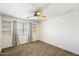 Cozy bedroom with neutral carpeting, a ceiling fan, and window with gray curtains at 3410 E Pageant Pl, Gilbert, AZ 85297