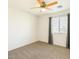 Cozy bedroom with ceiling fan, carpeted floors, and large window dressed with gray curtains at 3410 E Pageant Pl, Gilbert, AZ 85297