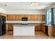 Bright kitchen features wood cabinets, a center island, and modern appliances at 3410 E Pageant Pl, Gilbert, AZ 85297