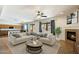Inviting living room featuring a fireplace, ceiling fan, and a smooth transition to the kitchen area at 3410 E Pageant Pl, Gilbert, AZ 85297
