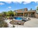 Backyard pool features a rock waterfall, surrounded by lush landscaping and a secure fence at 3410 E Pageant Pl, Gilbert, AZ 85297