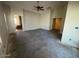 Large living room ready for new flooring, featuring high ceilings and natural light at 36452 W Velazquez Dr, Maricopa, AZ 85138