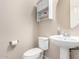 Half bath featuring a pedestal sink, updated fixtures and hardware and neutral color palette at 3687 E Blue Spruce Ln, Gilbert, AZ 85298