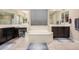 Bathroom showcasing a garden tub, dual sinks, neutral tile floor and dark wood cabinetry at 3687 E Blue Spruce Ln, Gilbert, AZ 85298